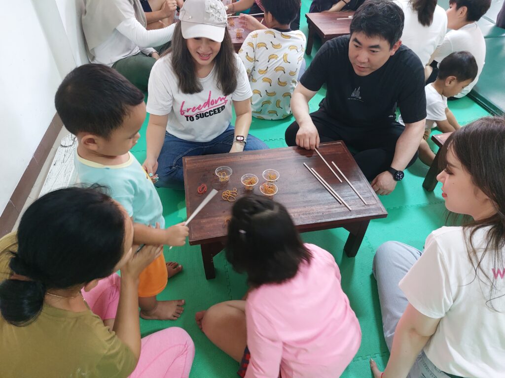 Volunteers sitting around a table with children.