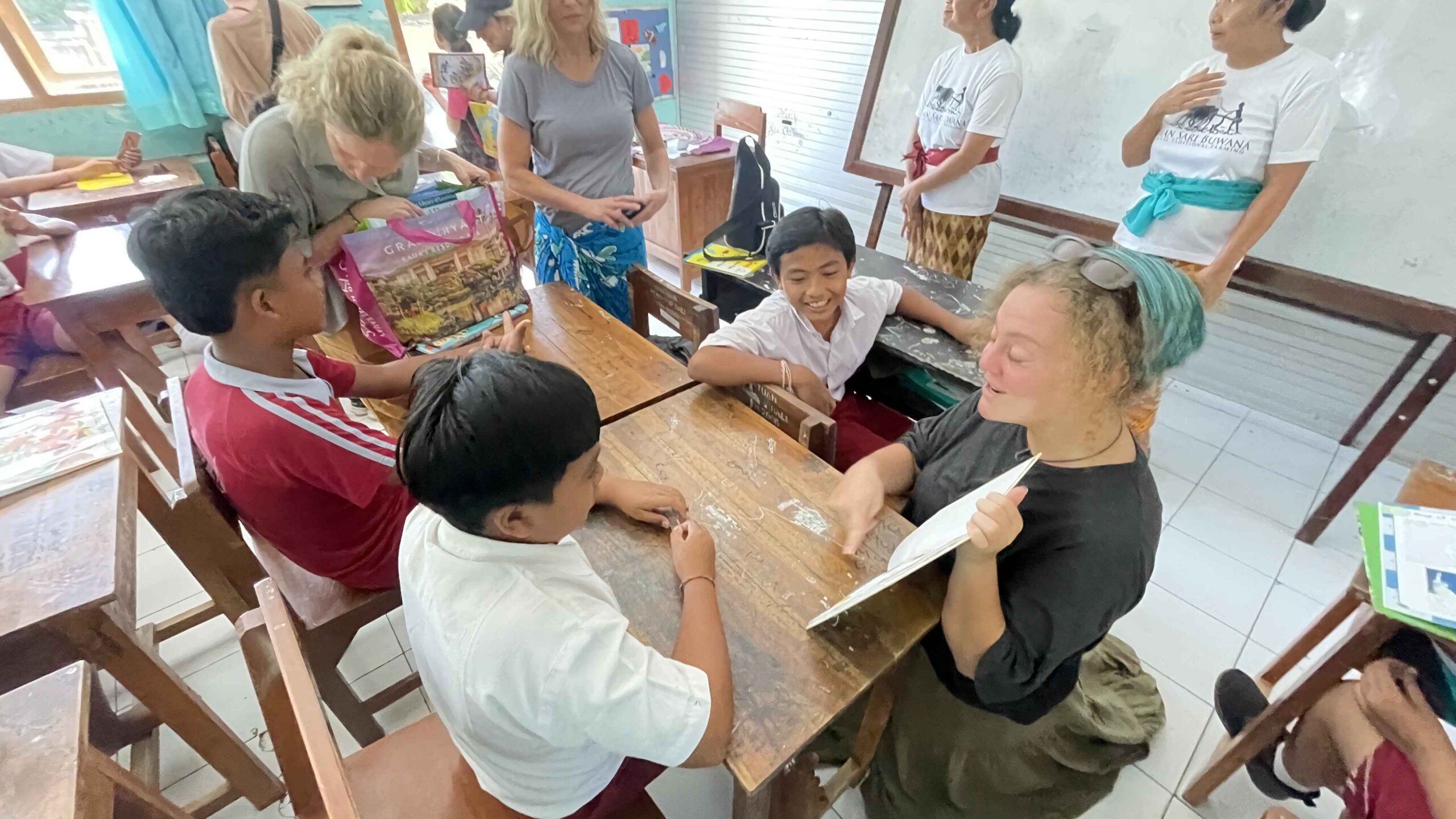 Volunteer showing a book to local children.
