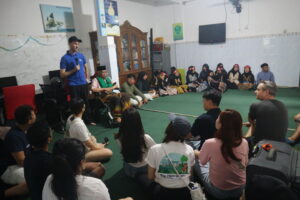 Volunteers and children sitting in a circle.