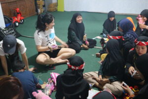 Volunteers playing in a circle on the floor.