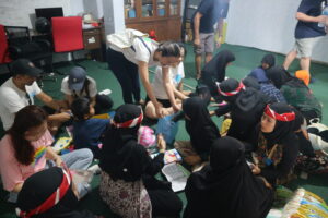 Children picking items out of a bag from a volunteer.