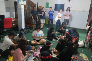 Volunteers sitting with the children on the floor.