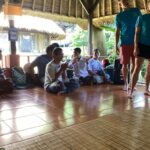 Local community pictured sitting on the floor of the pavilion.