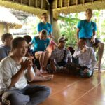 Volunteers and local community members sitting together.