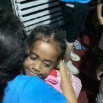 A volunteer hugging a local child.