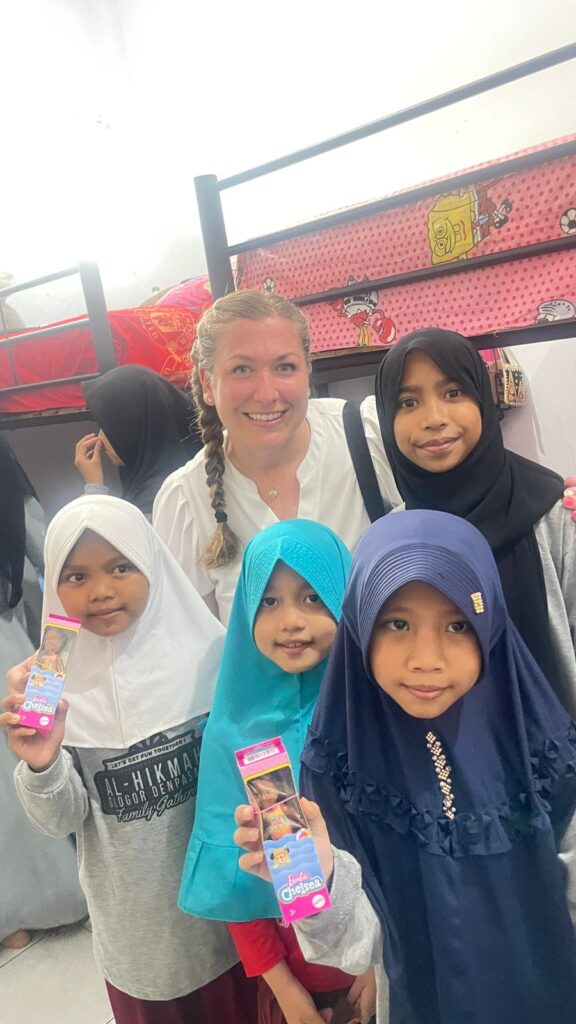 Volunteer and local children showing off their new toys.
