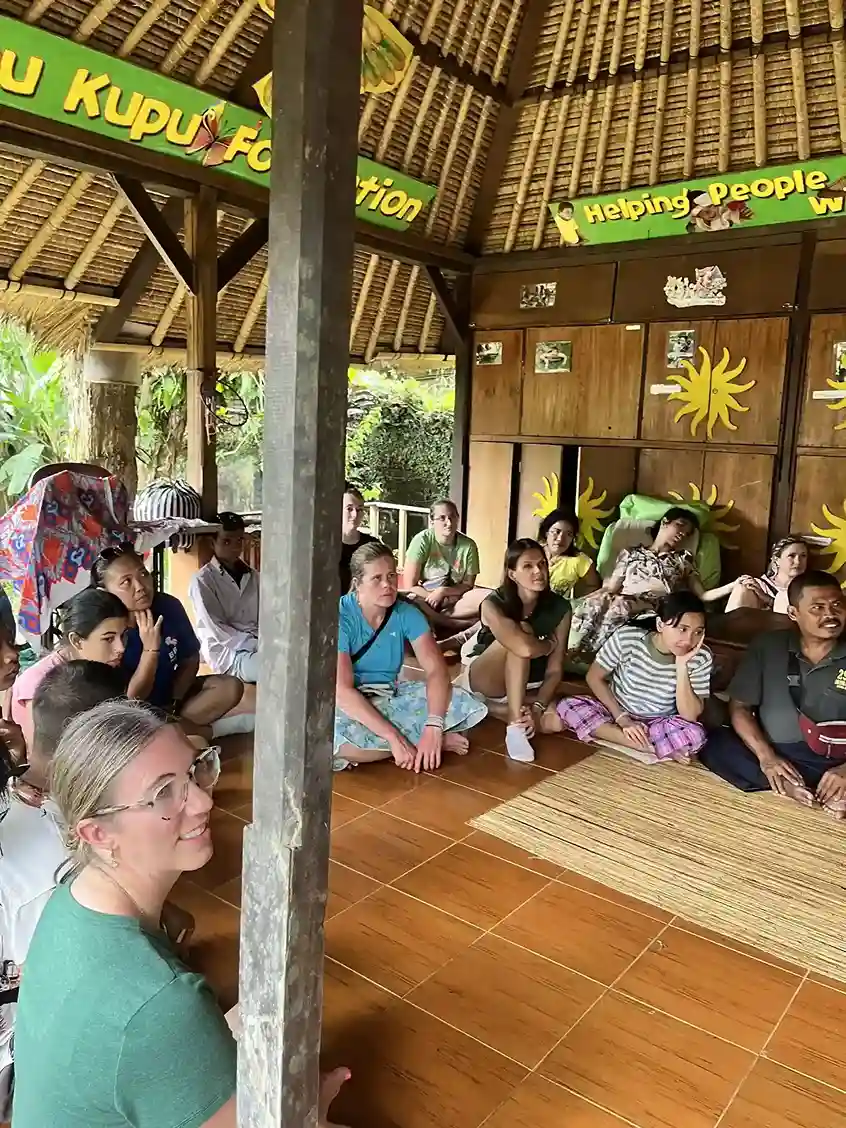 Volunteers sitting together under a pavilion.