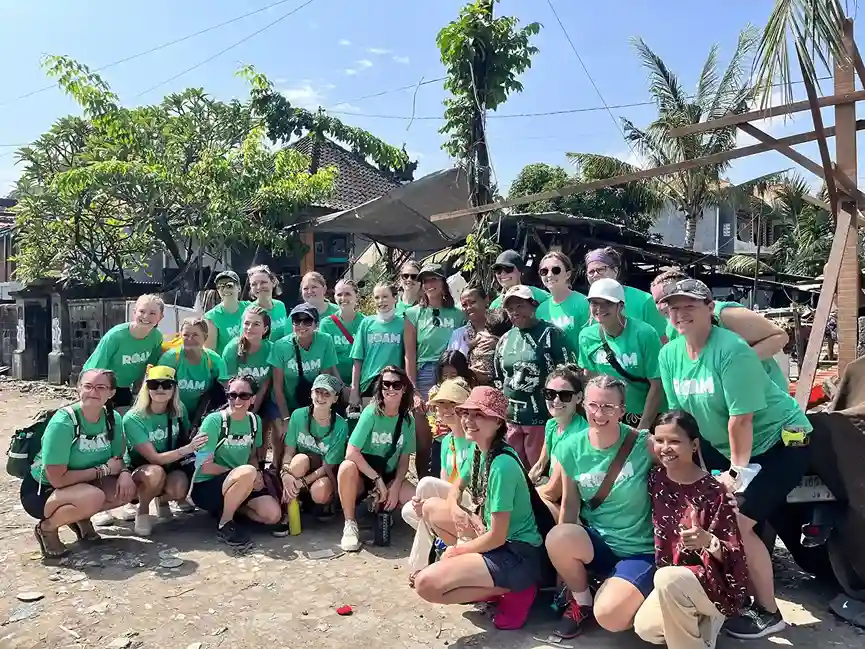 Volunteers in green shirts posing for a group picture.