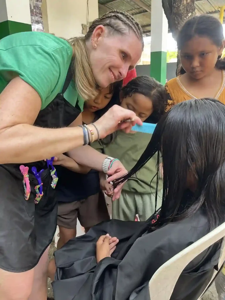 Volunteer giving a child a haircut.