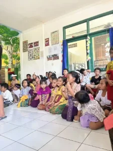 Local children sitting on the floor all together.