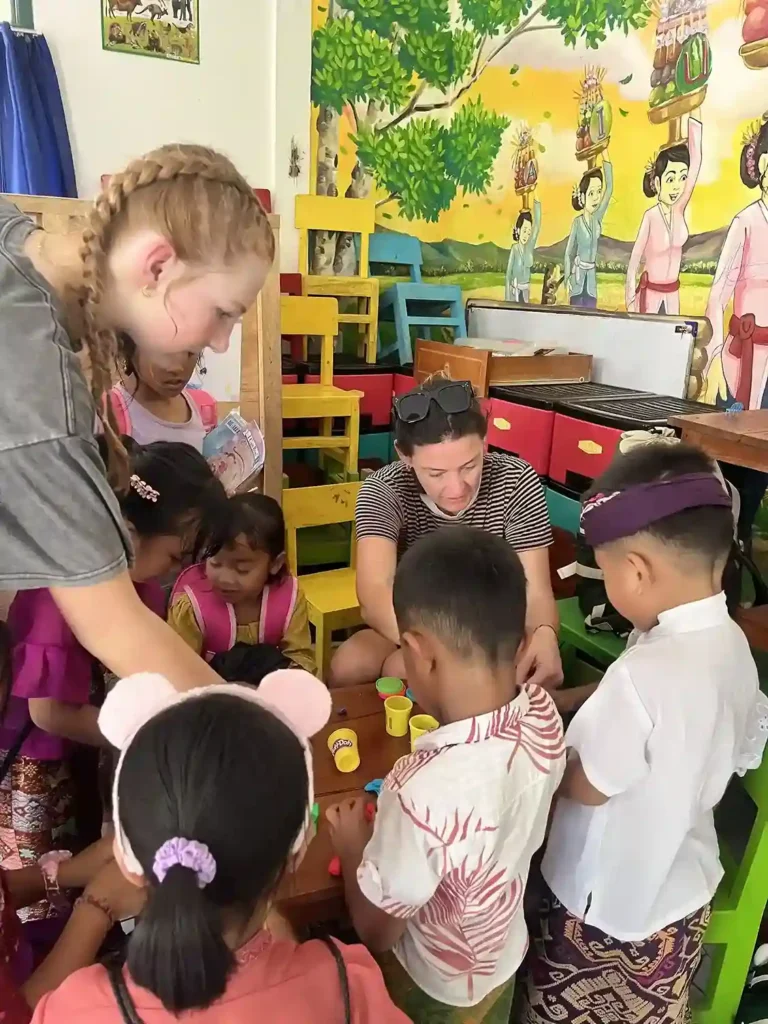 Volunteers helping local children play with Play-Doh.