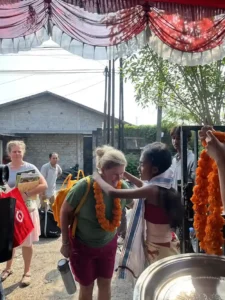 Community member placing a lei on a volunteer.