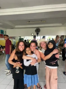 Volunteers and community members hugging for a picture.